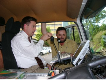 Scan team member Lacy Love (left) discusses use of the SCRIM machine to collect pavement data with a machine operator.