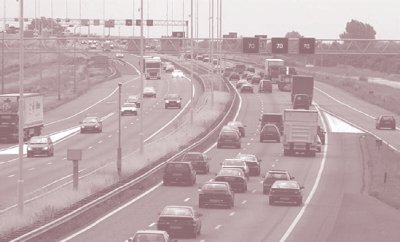 Photo of roadway with a left-side plus lane in the Netherlands and a variable speed limit side on an overhead gantry.