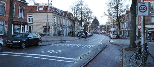 Figure 45 Main street - Description: View of a street with stores around it and cars on the side of the road.