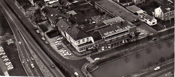 Redesign of the Kruisweg-Figure 71 Kruisweg in 1960 - Description: Many buildings with two roads with five lanes next to it. There is a body of water located in front of the largest building that has Bert Muller on it. 